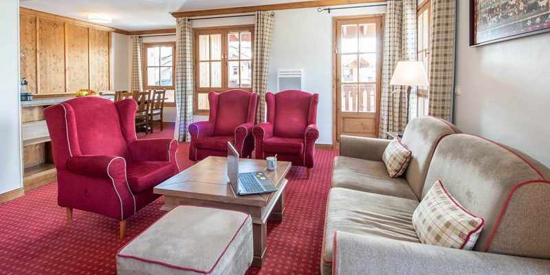 Arc 1950 le Village Arc 1950 Paradiski Frankrijk wintersport skivakantie luxe living grijze bank hocker rode fauteuils salontafel laptop eetkamer schilderij ramen