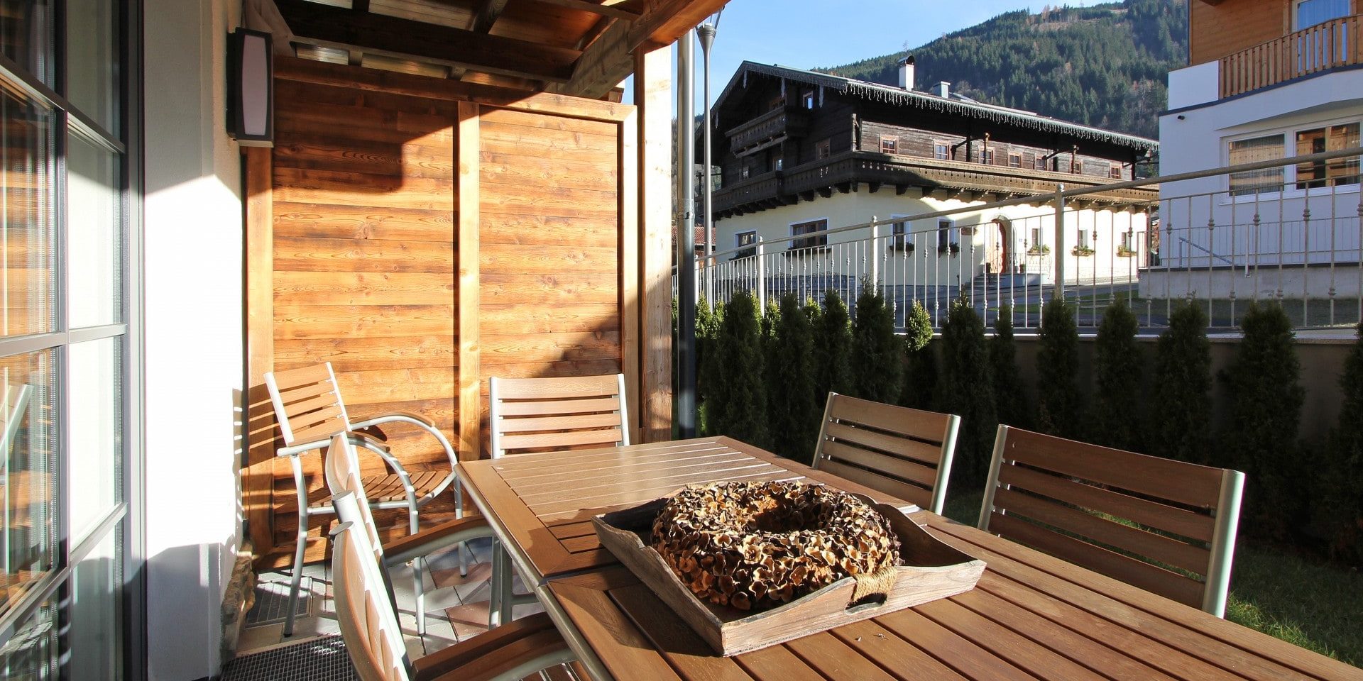 Avenida Mountain Resort Kaprun Zell am See-Kaprun Oostenrijk wintersport skivakantie luxe terras tafel stoelen hout bomen chalets appartementen