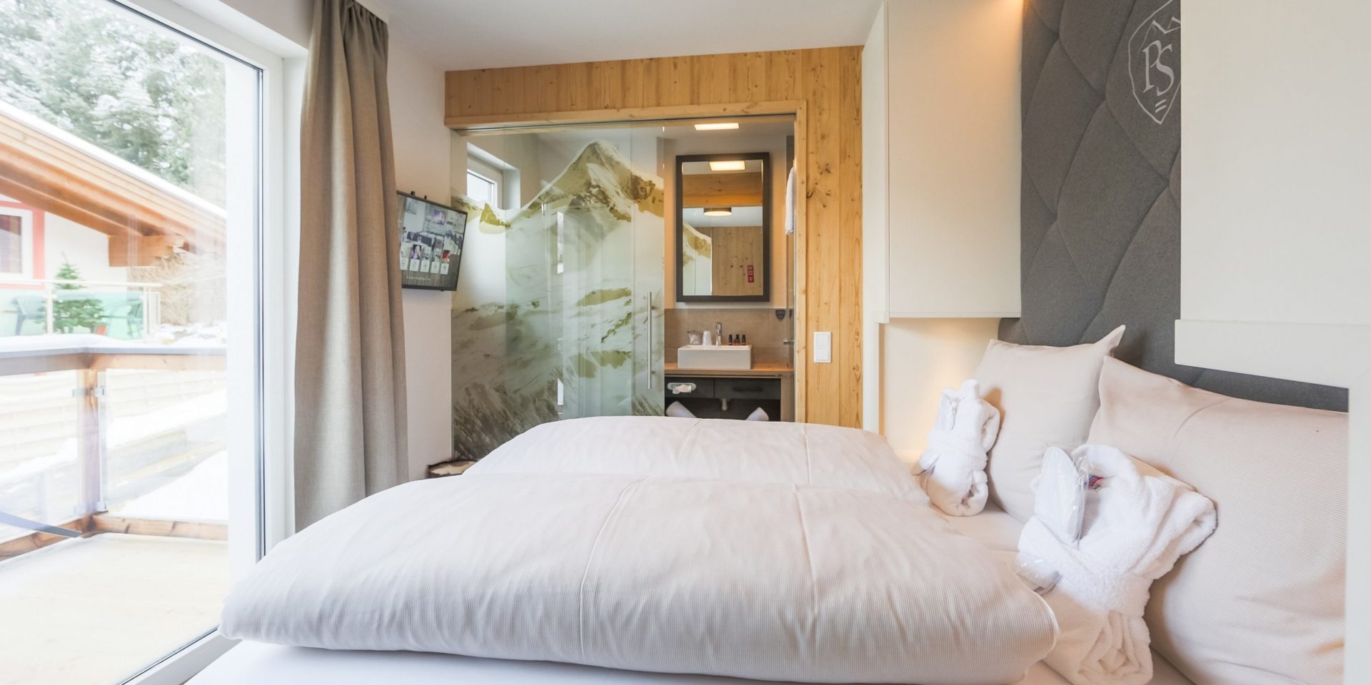 Hotel Avenida Panorama Suites Kaprun Zell am See-Kaprun Oostenrijk wintersport skivakantie luxe Suites bijgebouw 2-persoonsbed hoofdbord TV muurschildering badkamer wastafel spiegel balkon