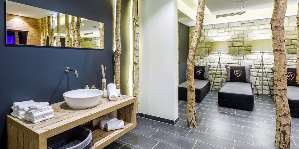 Hotel Avenida Panorama Suites Kaprun Zell am See-Kaprun Oostenrijk wintersport skivakantie luxe Spa ligstoelen wastafel spiegel boomstammen handdoeken sfeerverlichting