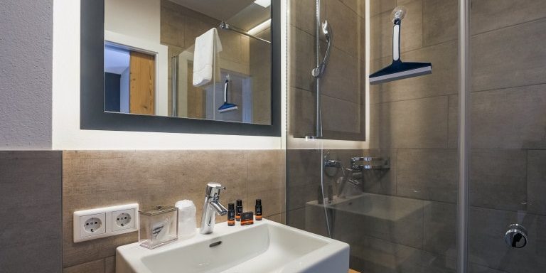 Hotel Avenida Panorama Suites Kaprun Zell am See-Kaprun Oostenrijk wintersport skivakantie luxe Suites 311 312 badkamer douche wastafel spiegel handdoek