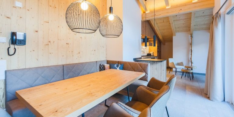 Penthouses Avenida Panorama Suites Kaprun Zell am See-Kaprun Oostenrijk wintersport skivakantie luxe Penthouse 3 living eettafel leren hoekbank leren stoelen hanglampen keuken fauteuil houten balken