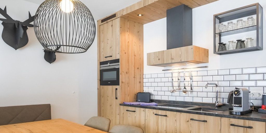 Hotel Avenida Panorama Suites Kaprun Zell am See-Kaprun Oostenrijk wintersport skivakantie luxe Suites Sauna 323 eettafel stoelen hanglamp herten keuken afzuigkap hout