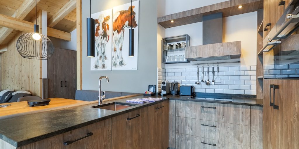 Penthouses Avenida Panorama Suites Kaprun Zell am See-Kaprun Oostenrijk wintersport skivakantie luxe Penthouse 4 keuken keukenblok schilderij koeien eettafel bankje hanglamp houten balken