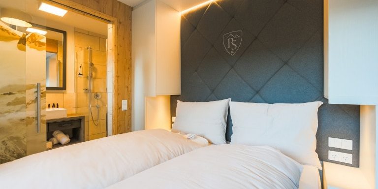 Hotel Avenida Panorama Suites Kaprun Zell am See-Kaprun Oostenrijk wintersport skivakantie luxe Suites 113 114 slaapkamer 2-persoonsbed hoofdbord wandlampen muurschildering badkamer wastafel douche spiegel