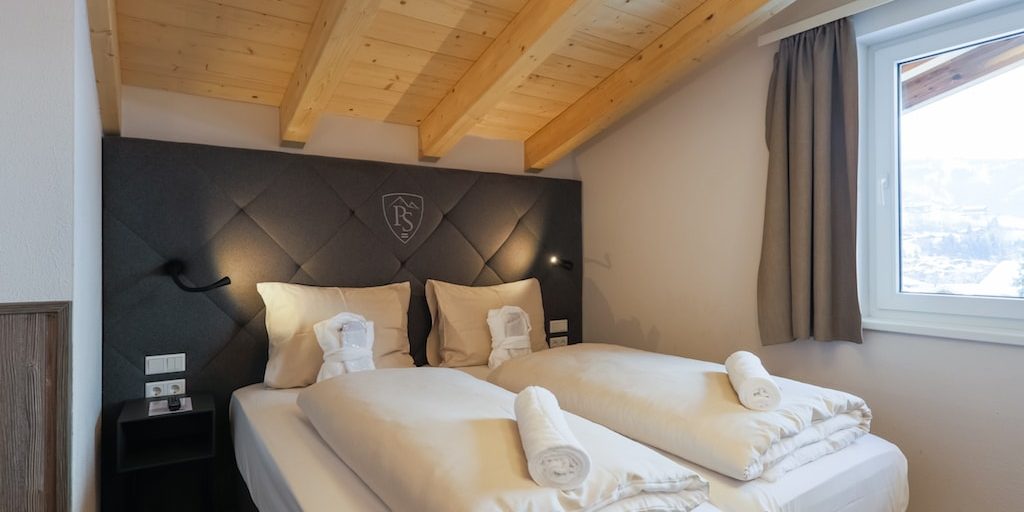 Penthouses Avenida Panorama Suites Kaprun Zell am See-Kaprun Oostenrijk wintersport skivakantie luxe Penthouse 4 slaapkamer aparte bedden hoofdbord nachtlampjes houten balken raam
