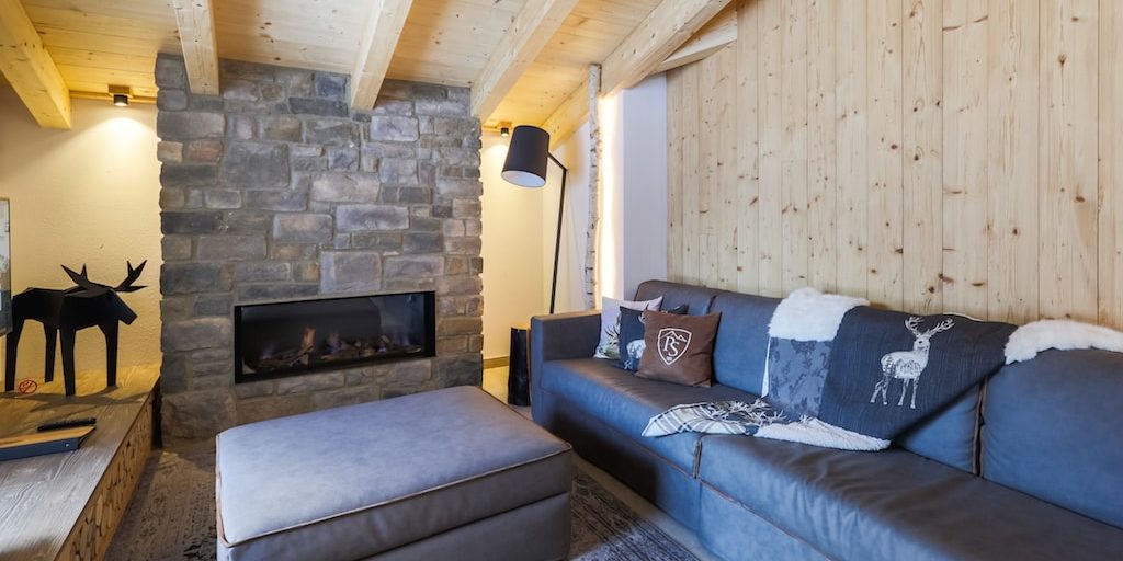 Penthouses Avenida Panorama Suites Kaprun Zell am See-Kaprun Oostenrijk wintersport skivakantie luxe Penthouse 4 living open haard leren bank kussens hocker eland TV houten wand houten balken