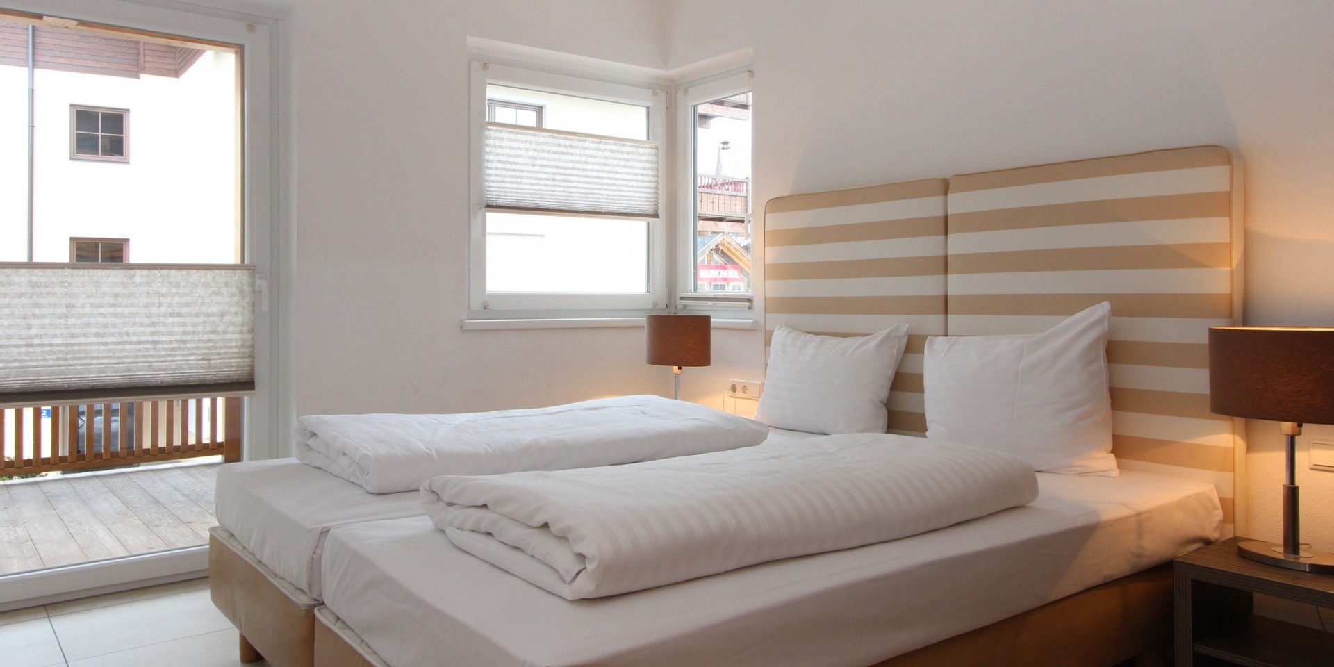 Avenida Style Kaprun Zell am See-Kaprun Oostenrijk wintersport skivakantie luxe Top 5 slaapkamer aparte bedden gestreept hoofdbord nachtlampjes balkon ramen