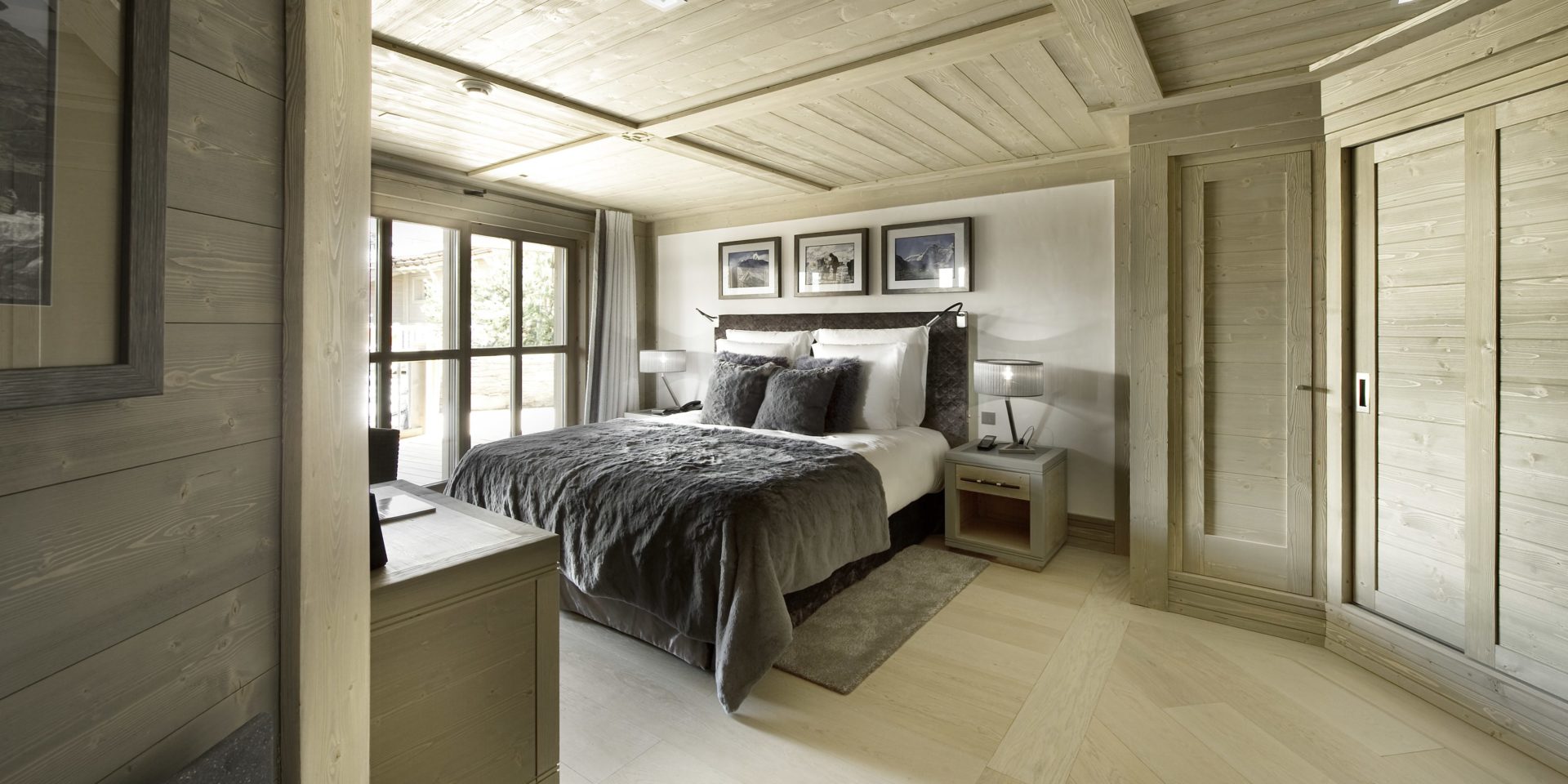 Le K2 Palace Suite-Chalet Abruzzes Courchevel Les 3 Vallees Frankrijk wintersport skivakantie luxe slaapkamer 2-persoonsbed hout schilderijen raam vloerkleed nachtlampjes houten plafond