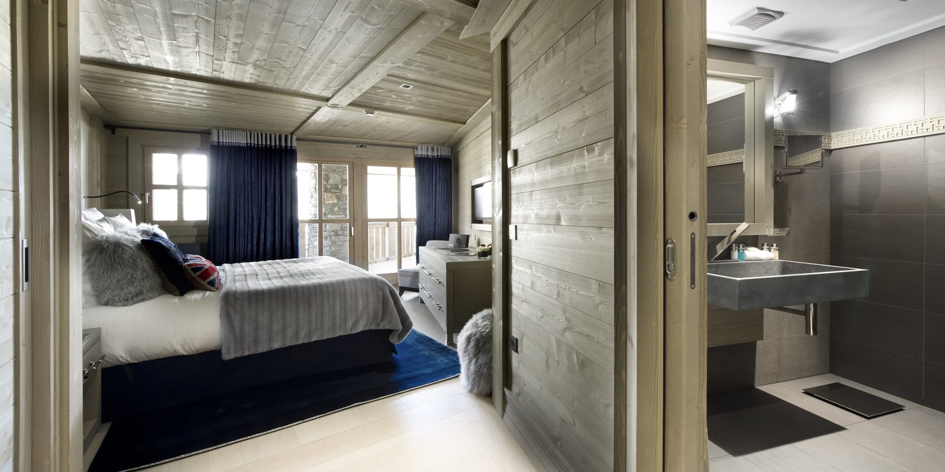 Le K2 Palace Suite-Chalet Abruzzes Courchevel Les 3 Vallees Frankrijk wintersport skivakantie luxe slaapkamer 2-persoonsbed hout TV raam vloerkleed houten plafond badkamer wastafel spiegel