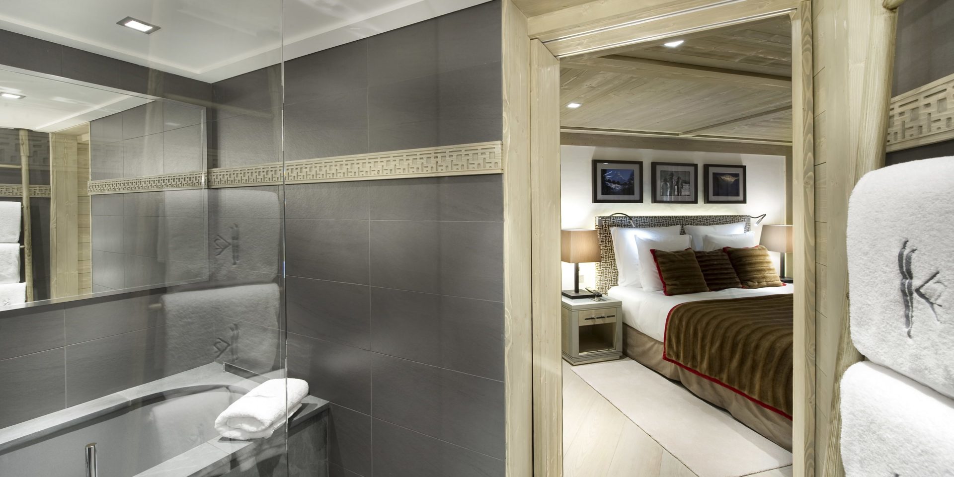 Le K2 Palace Suite-Chalet Abruzzes Courchevel Les 3 Vallees Frankrijk wintersport skivakantie luxe badkamer bad spiegel handdoeken slaapkamer 2-persoonsbed vloerkleed houten plafond