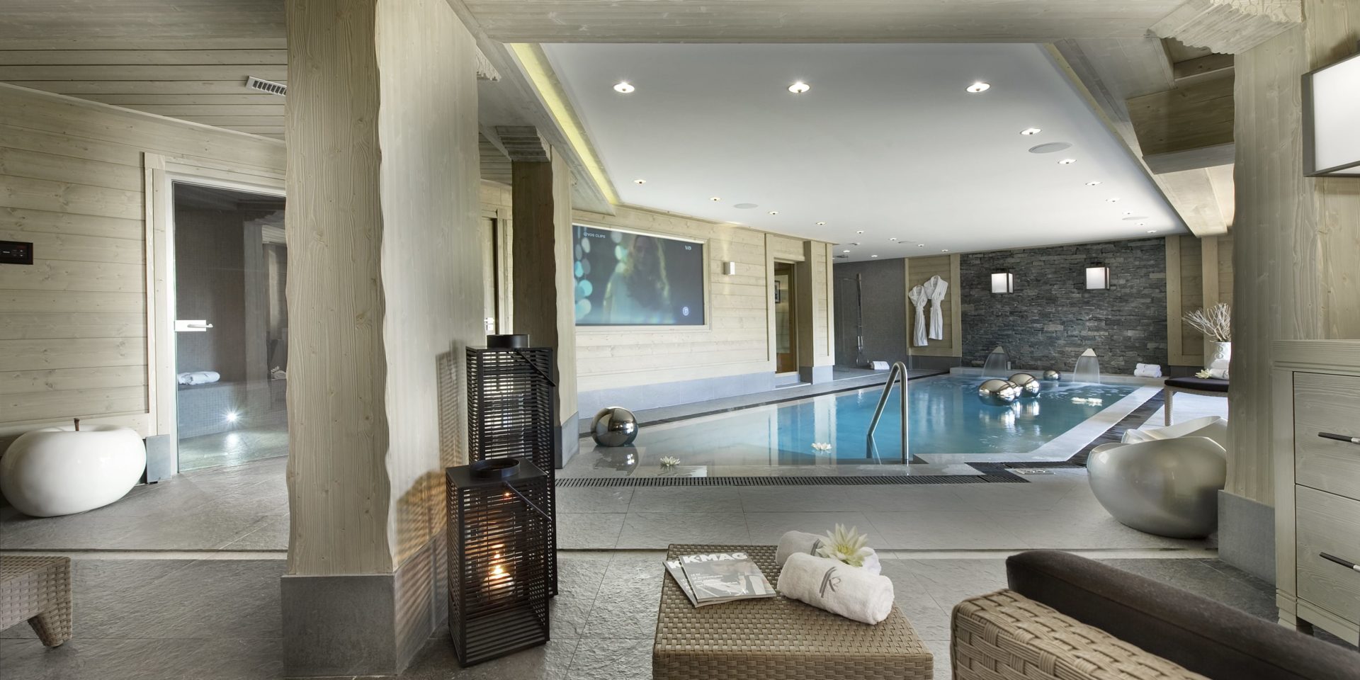 Le K2 Palace Suite-Chalet Abruzzes Courchevel Les 3 zwembad zitje fauteuil hocker windlichten witte appel badjassen handdoeken grote flatscreen hout zwemmen ontspannen relaxen genieten
