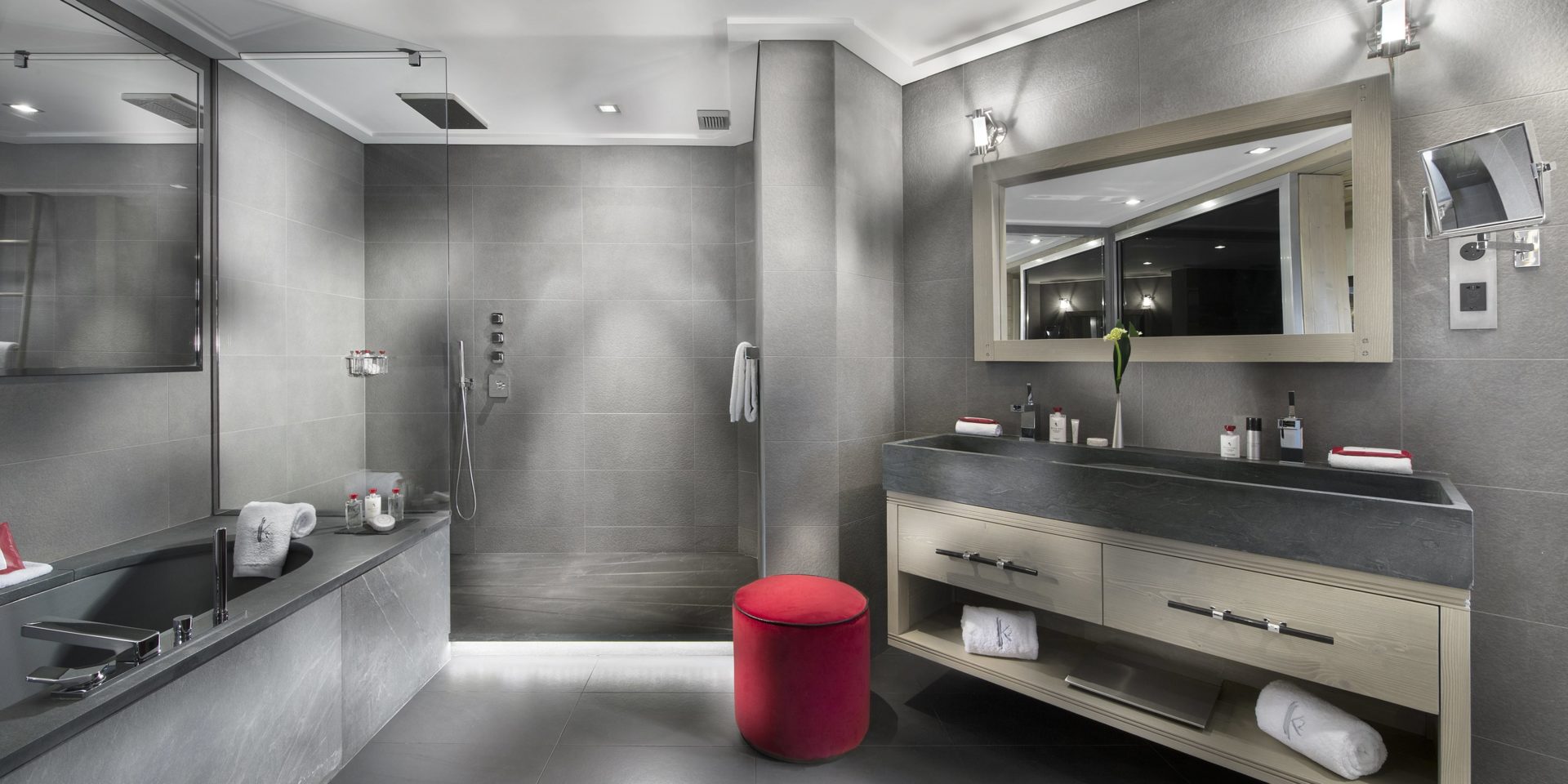 Le K2 Palace Suite-Chalet Baltoro Courchevel Les 3 Vallees Frankrijk wintersport skivakantie luxe badkamer bad douche grote wasbak grote spiegel rode hocker handdoeken wandlampen