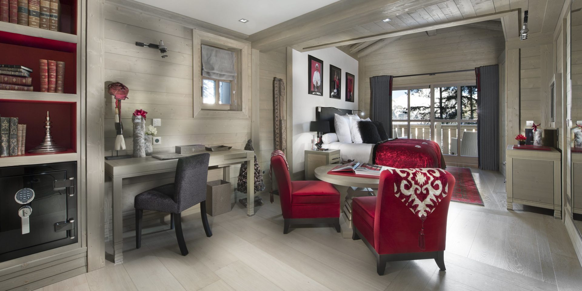 Le K2 Palace Suite-Chalet Baltoro Courchevel Les 3 Vallees Frankrijk wintersport skivakantie luxe slaapkamer rode fauteuils salontafel bureau stoel kluis boeken vloerkleed 2-persoonsbed kussens schilderijen raam balkon stoelen houten balken