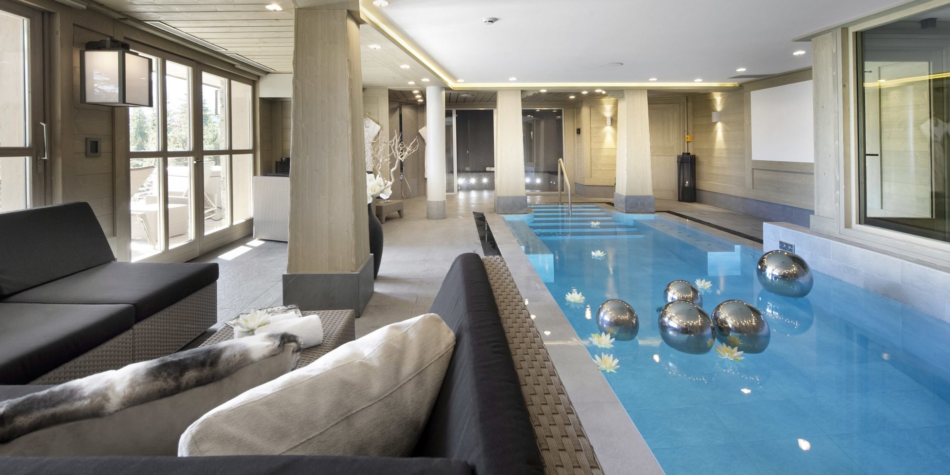 Le K2 Palace Suite-Chalet Baltoro Courchevel Les 3 Vallees Frankrijk wintersport skivakantie luxe zwembad wicker hoekbank kussens hocker zilveren bellen terras ligstoelen hout zwemmen ontspannen relaxen genieten