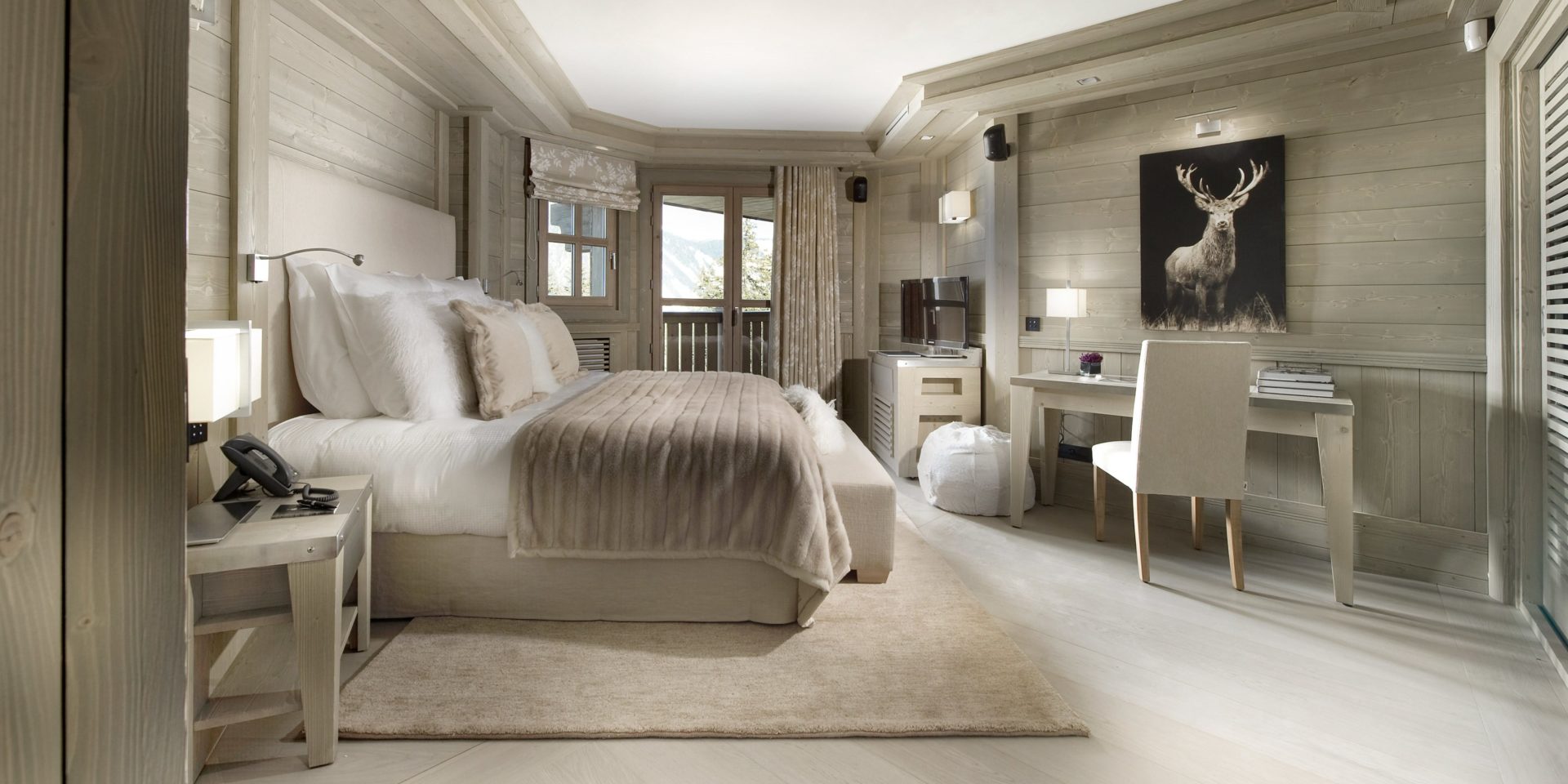 Le K2 Palace Suite-Chalet Karakoram Courchevel Les 3 Vallees Frankrijk wintersport skivakantie luxe slaapkamer 2-persoonsbed vloerkleed schilderij hert bureau stoel raam balkon