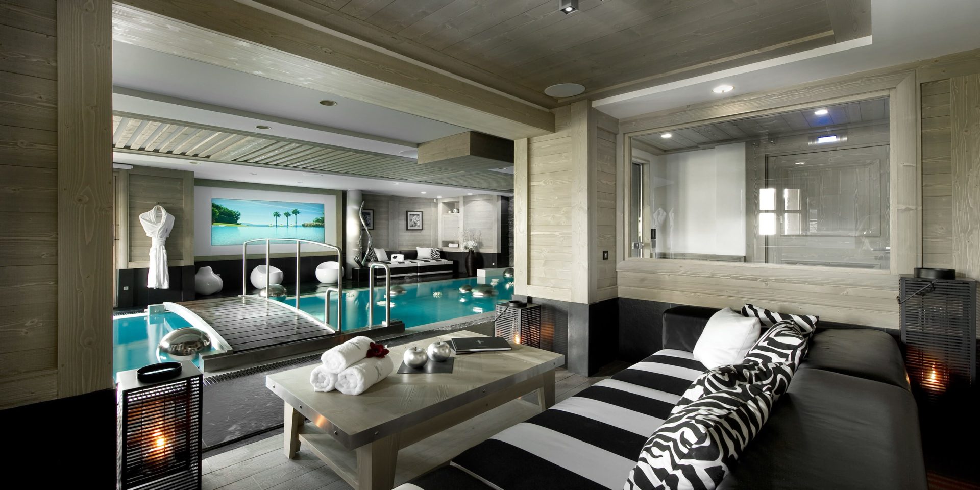 Le K2 Palace Suite-Chalet Karakoram Courchevel Les 3 Vallees Frankrijk wintersport skivakantie luxe zwembad zwart wit gestreepte banken salontafel handdoeken windlichten zwembad bruggetje badjas zwemmen ontspannen relaxen genieten