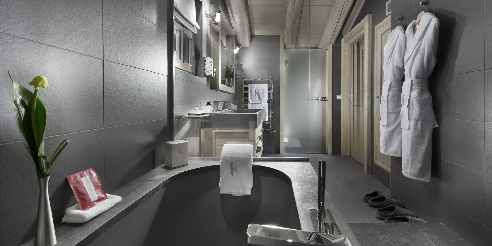 Le K2 Palace Suite-Chalet Panmah Courchevel Les 3 Vallees Frankrijk wintersport skivakantie luxe badkamer bad wasbak spiegel handdoekenrek badjassen slippers houten balken