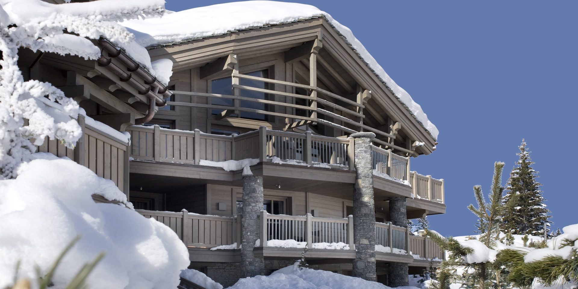 Le K2 Palace Suite-Chalet Panmah Courchevel Les 3 Vallees Frankrijk wintersport skivakantie luxe voorzijde chalet Panmah balkons ligging besneeuwde bomen sneeuw