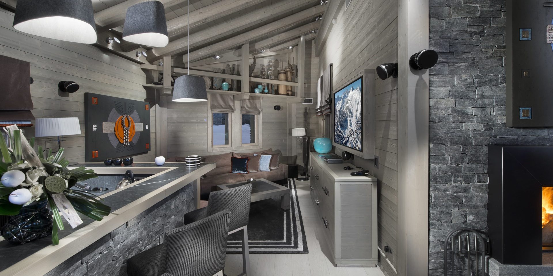 Le K2 Palace Suite-Chalet Panmah Courchevel Les 3 Vallees Frankrijk wintersport skivakantie luxe living bar barkrukken bloemen kunst bank salontafel TV hanglampen vloerkleed houten balken