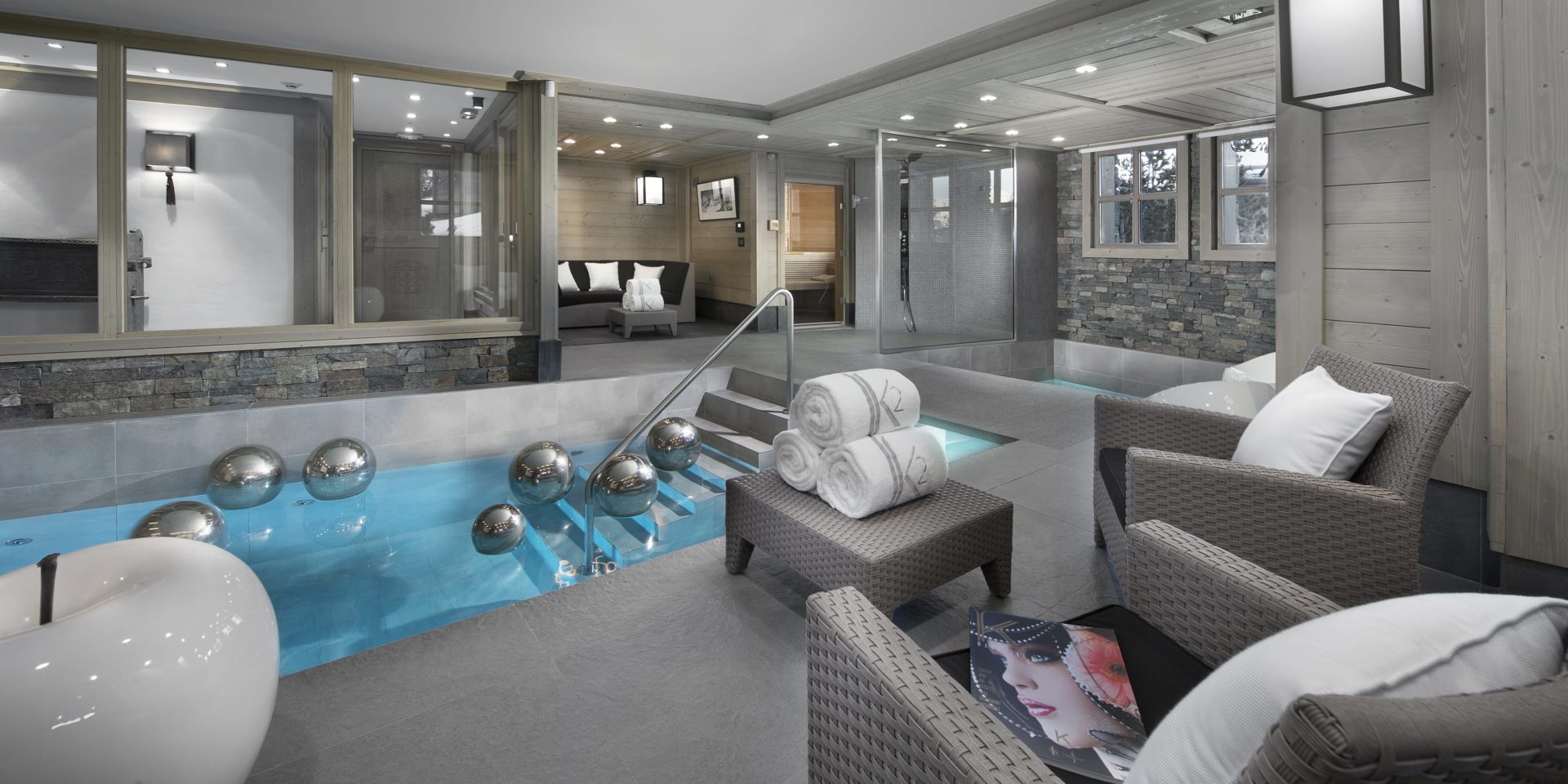 Le K2 Palace Suite-Chalet Panmah Courchevel Les 3 Vallees Frankrijk wintersport skivakantie luxe zwembad wicker fauteuils hocker handdoeken hoekbank witte appel zilveren bellen ramen douche zwemmen ontspannen relaxen genieten