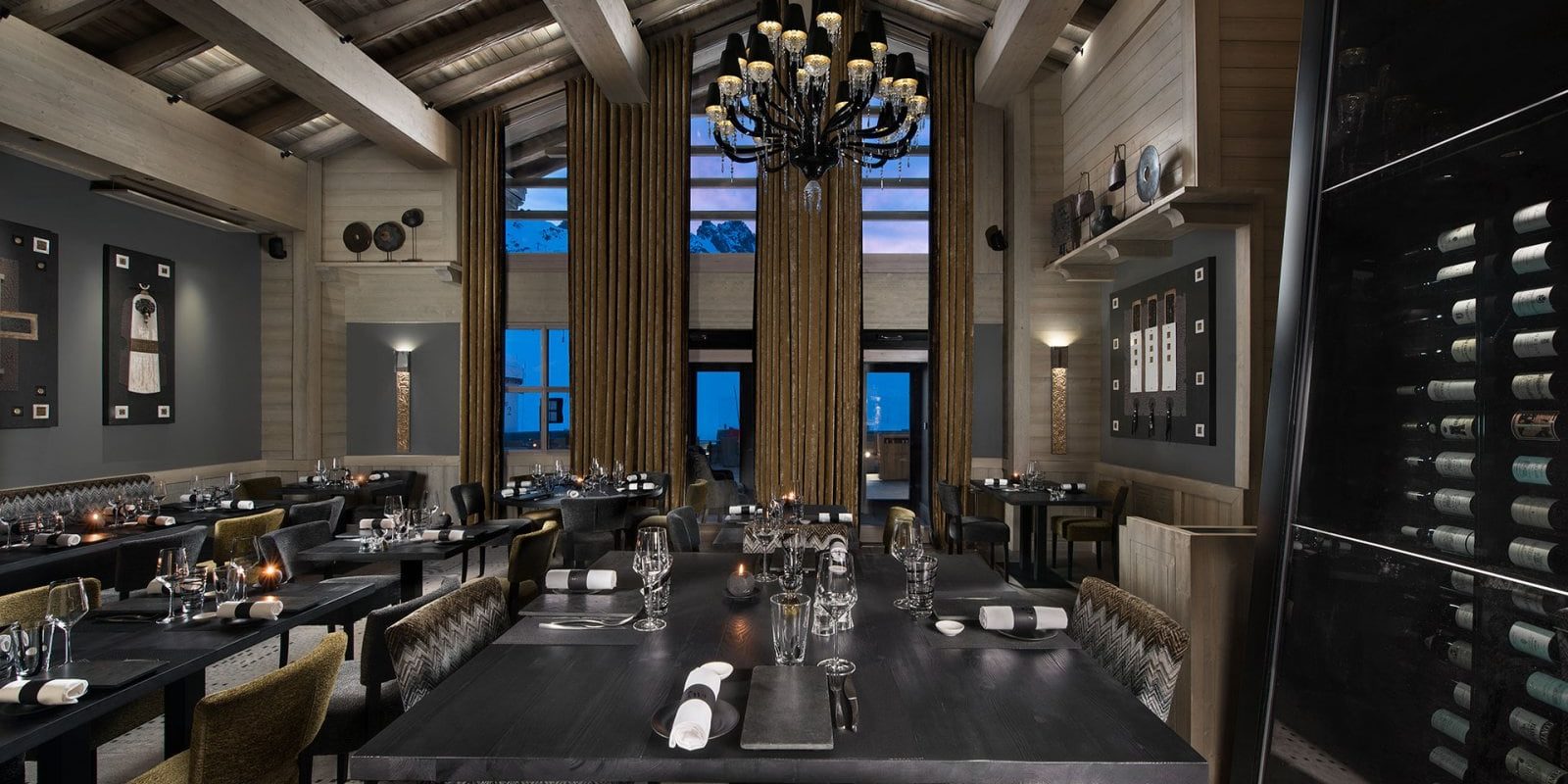 Hotel Le K2 Altitude Courchevel Les 3 Vallees Frankrijk wintersport skivakantie luxe Le Montgomerie restaurant gedekte tafels wijnglazen kroonluchter groene gestreepte stoffen stoelen wijnen hoge ramen hout