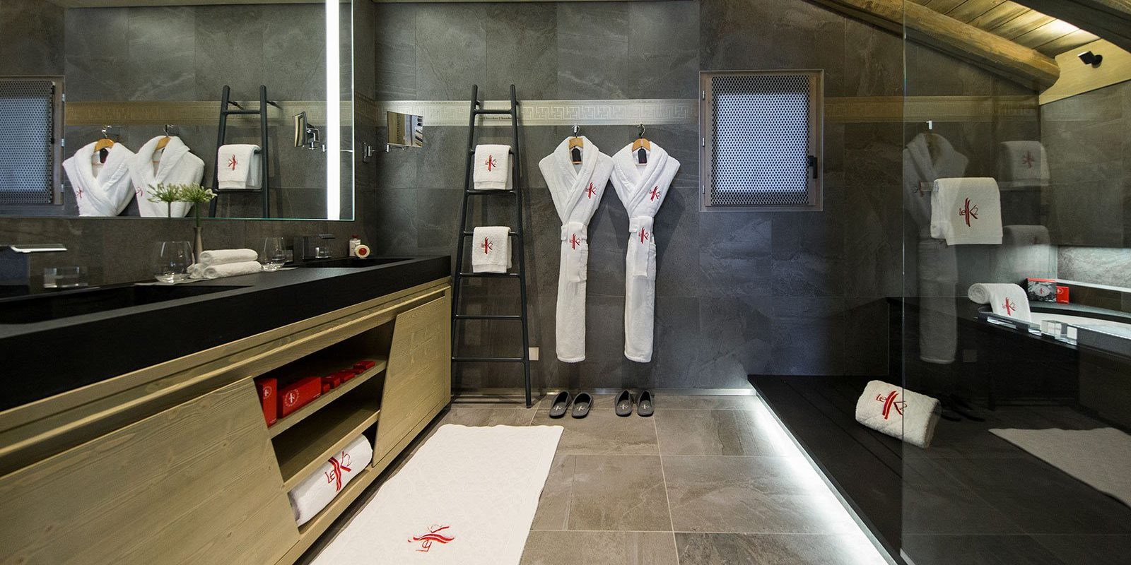 Hotel Le K2 Altitude Courchevel Les 3 Vallees Frankrijk wintersport skivakantie luxe Suite Altitude badkamer dubbele wasbak grote spiegel badhanddoeken badjassen slippers raam houten balken