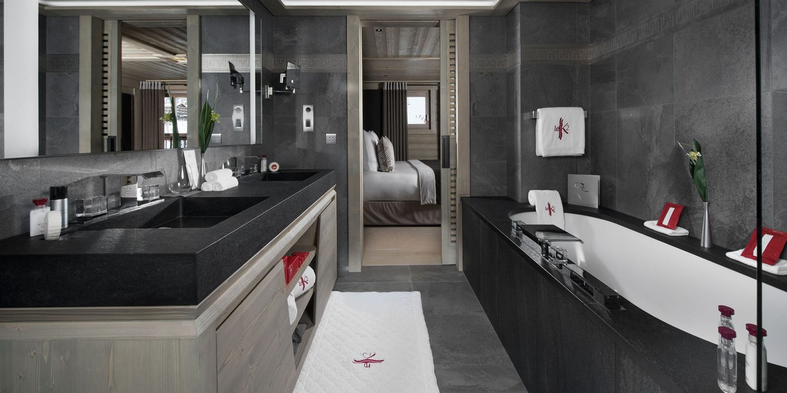 Hotel Le K2 Altitude Courchevel Les 3 Vallees Frankrijk wintersport skivakantie luxe badkamer bad dubbele wasbak grote spiegel handdoeken bloemen slaapkamer