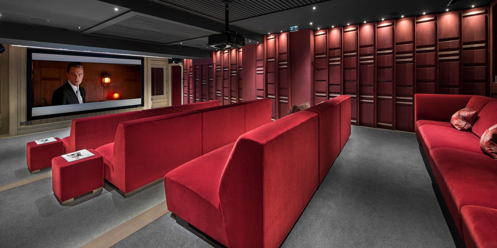 Hotel Le K2 Altitude Courchevel Les 3 Vallees Frankrijk wintersport skivakantie luxe bioscoop rode loungebanken kussens hocker grote flatscreen grijze vloerbedekking