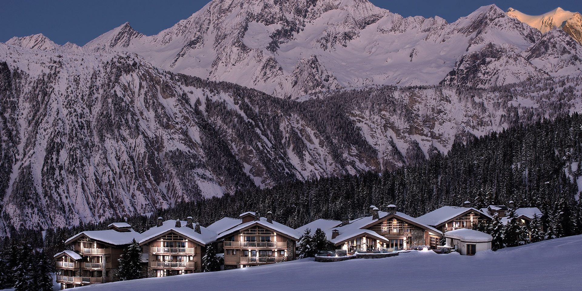 Hotel Le K2 Altitude Courchevel Les 3 Vallees Frankrijk wintersport skivakantie luxe ligging Hotel Le K2 Altitude Courchevel besneeuwde bergen bomen sneeuw verlichting