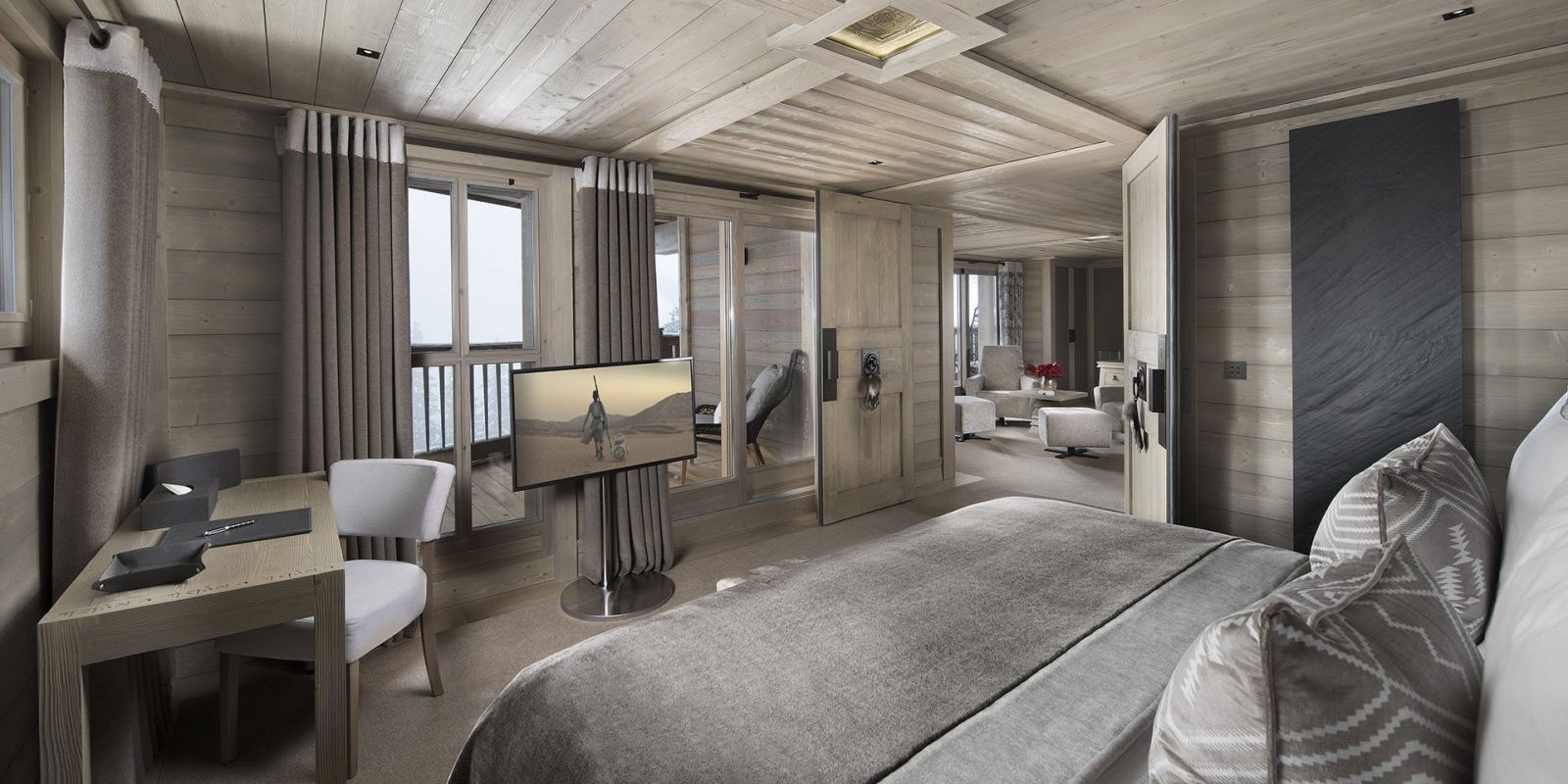 Hotel Le K2 Altitude Courchevel Les 3 Vallees Frankrijk wintersport skivakantie luxe Suite 2-persoonsbed bureau witte stoel TV ramen balkon stoelen living houten plafond