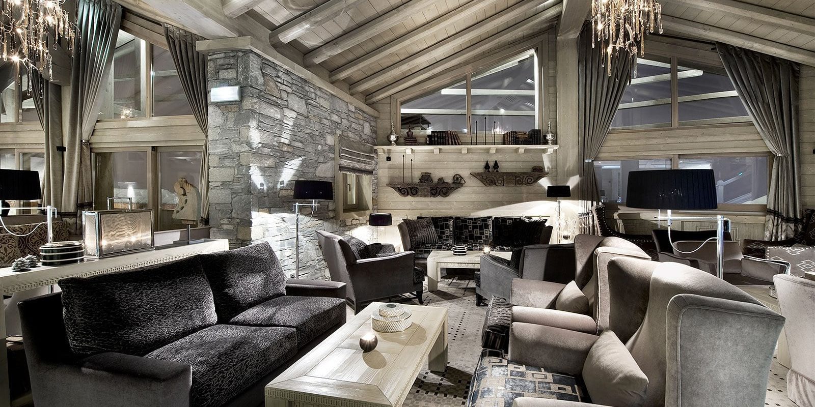 Hotel Le K2 Palace Courchevel Les 3 Vallees Frankrijk wintersport skivakantie luxe lounge banken fauteuils salontafels kroonluchter stenen muur ramen vloerbedekking houten balken houten plafond