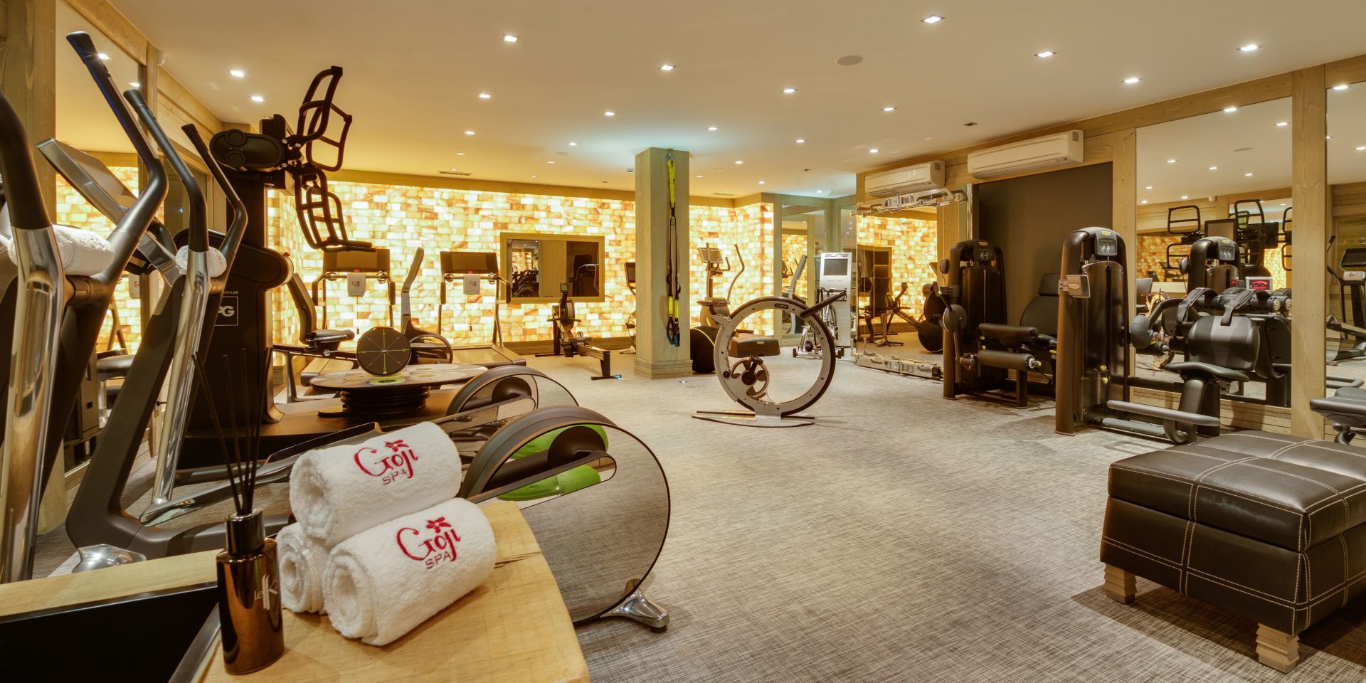 Hotel Le K2 Palace Courchevel Les 3 Vallees Frankrijk wintersport skivakantie luxe fitness apparaten crosstrainer loopbanden hocker handdoeken geel geblokte muur vloerbedekking verlichting spotjes