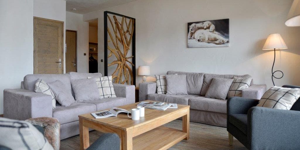 Residence Carlina Belle Plagne Paradiski Frankrijk wintersport skivakantie luxe living grijze banken kussens salontafel grijze fauteuils schilderij ijsberen kamerscherm lamp