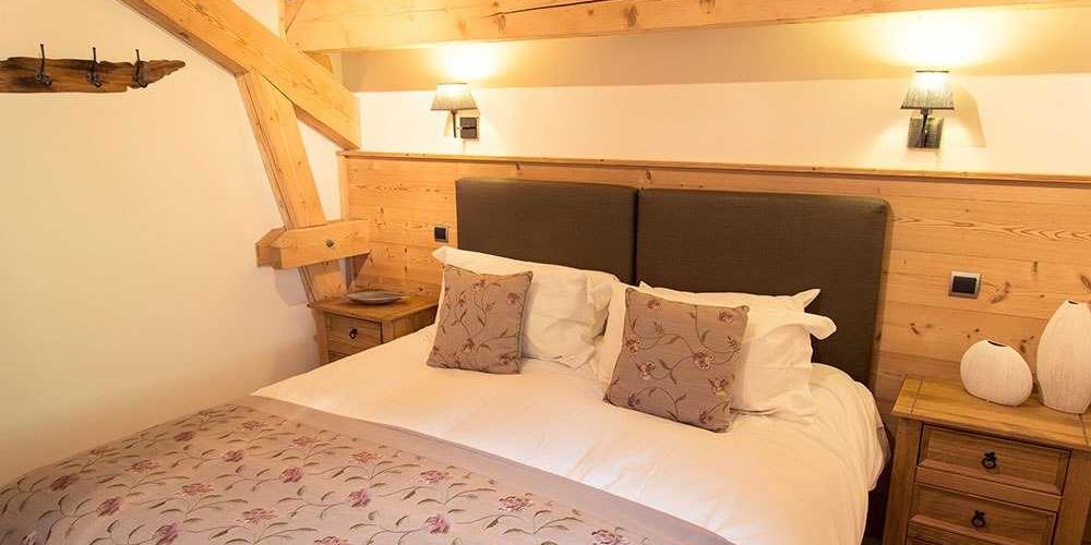 Chalet Belle Vache Chatel Les Portes du Soleil Frankrijk wintersport skivakantie luxe slaapkamer 2-persoonsbed kapstok wandlampen vazen houten balken