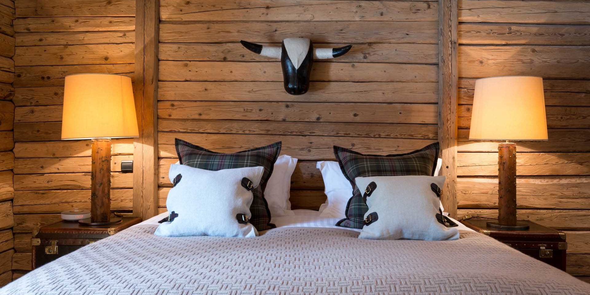 Chalet Ferme de Moudon Les Gets Les Portes du Soleil Frankrijk wintersport skivakantie luxe slaapkamer 2-persoonsbed kussens stierenkop nachtlampjes kisten houten wanden houten balken