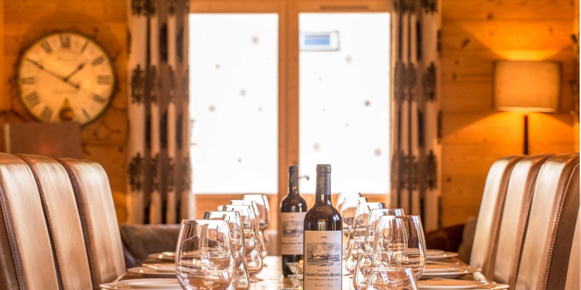 Chalet Grand Coeur Chatel Les Portes du Soleil Frankrijk wintersport skivakantie luxe eetkamer gedekte tafel wijn wijnglazen stoelen klop gordijnen lampen raam tafelen