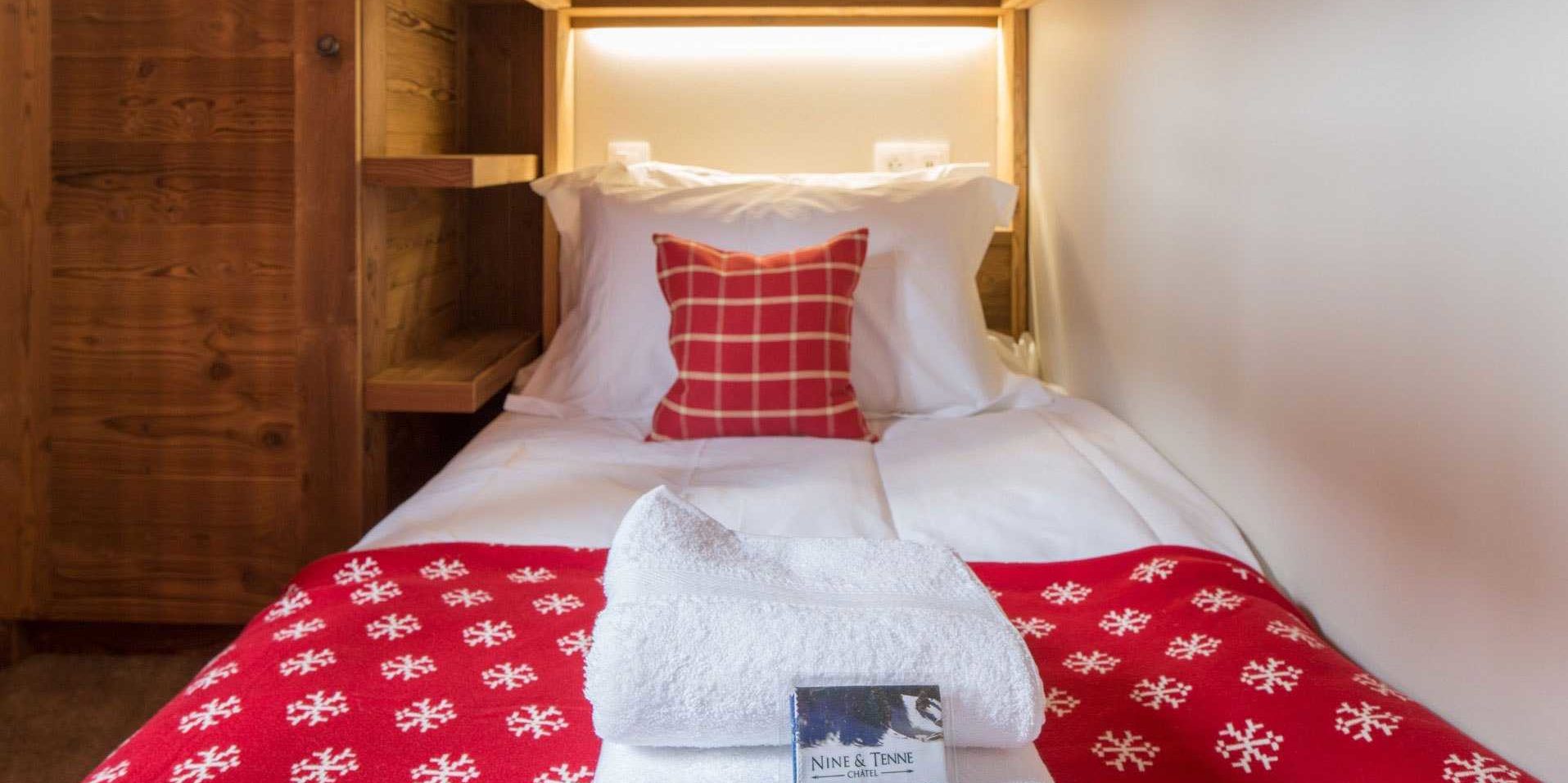 Chalet Les Clarines Chatel Les Portes du Soleil Frankrijk wintersport skivakantie luxe kinderslaapkamer stapelbed rood kussen rood kleed handdoeken houten wanden