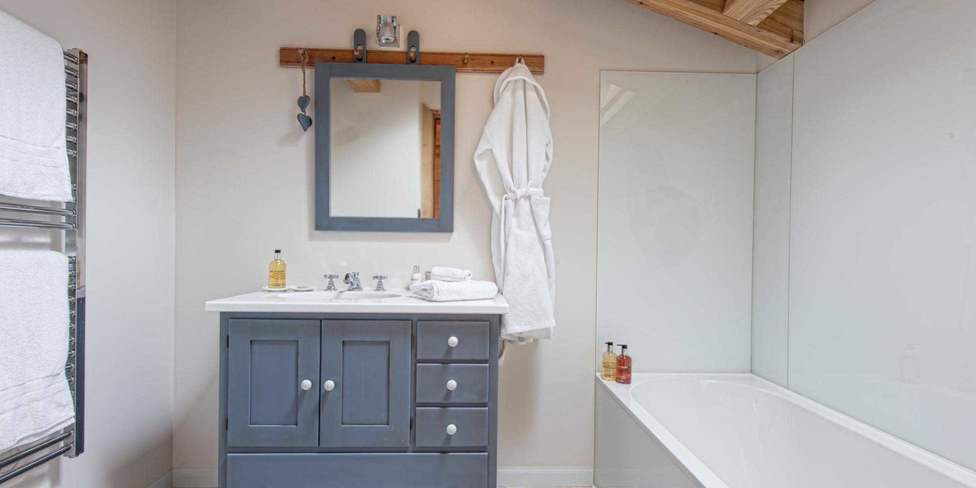 Chaletneuf du Tenne Chatel Les Portes du Soleil Frankrijk wintersport skivakantie luxe grijze badkamer bad wastafel spiegel handdoekenrek badjas houten balken
