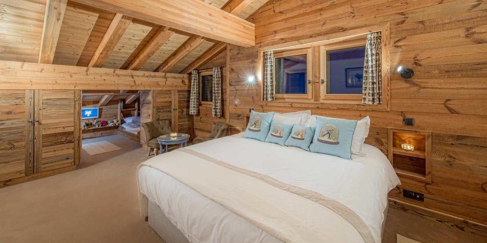 Chaletneuf du Tenne Chatel Les Portes du Soleil Frankrijk wintersport skivakantie luxe slaapkamer 2-persoonsbed blauwe kussens tafeltje fauteuils ramen 1-persoonsbed TV knuffels kindergedeelte houten wanden houten balken 3-persoonskamer