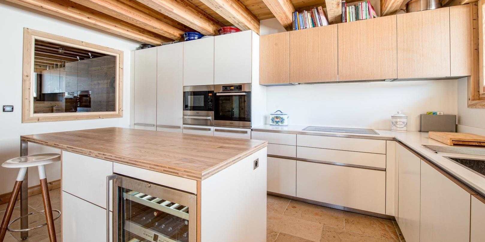 Chaletneuf du Tenne Chatel Les Portes du Soleil Frankrijk wintersport skivakantie luxe keuken eiland barkruk houten kastjes witte kastjes raam houten balken tegels