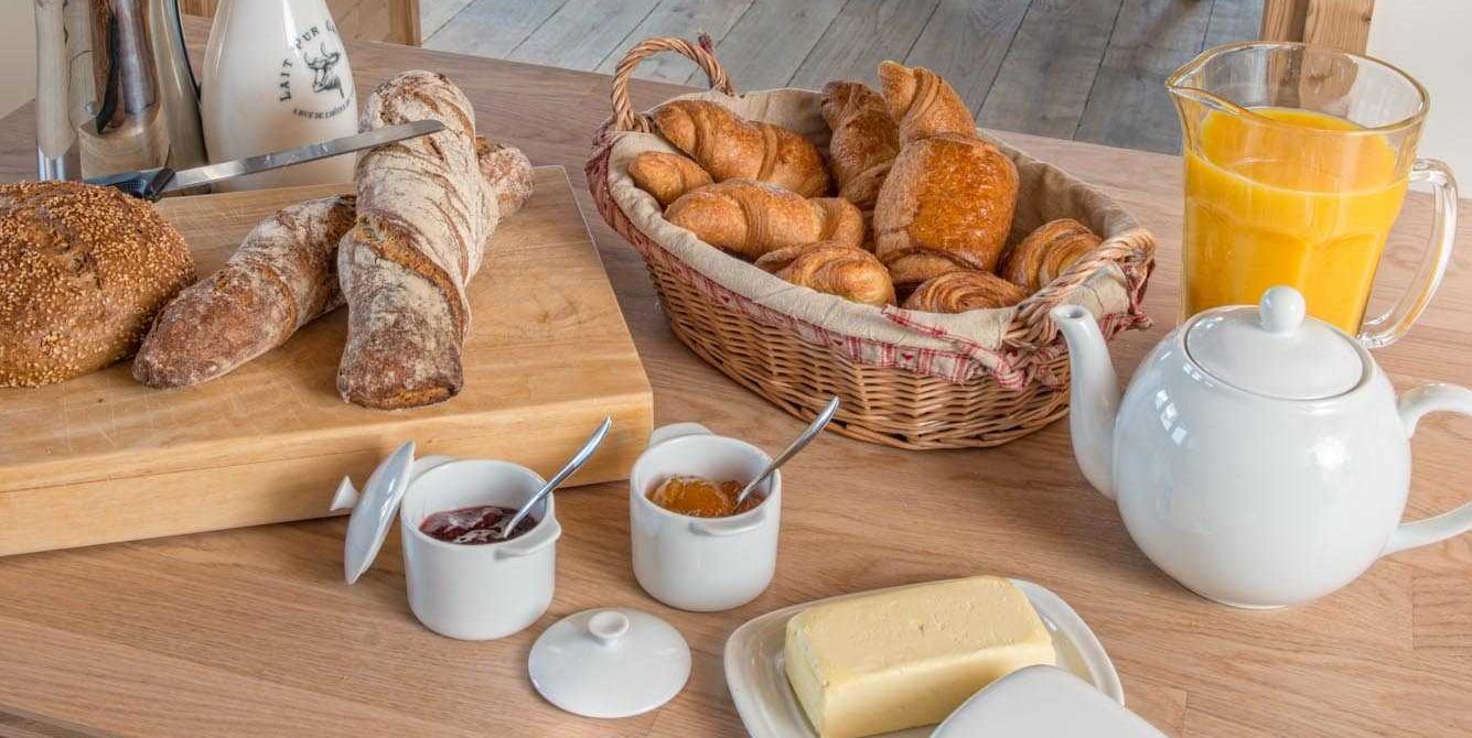 Chaletneuf du Tenne Chatel Les Portes du Soleil Frankrijk wintersport skivakantie luxe gedekte tafel ontbijt croissants jus d'orange jam boter stokbrood water thee broodplank