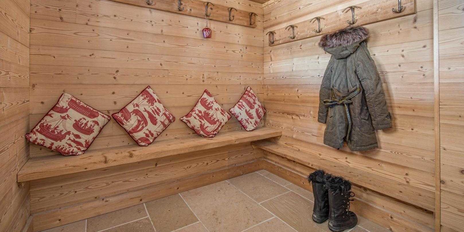 Chaletneuf du Tenne Chatel Les Portes du Soleil Frankrijk wintersport skivakantie luxe skiberging bankje wit rode kussens laarzen jas houten wanden tegels