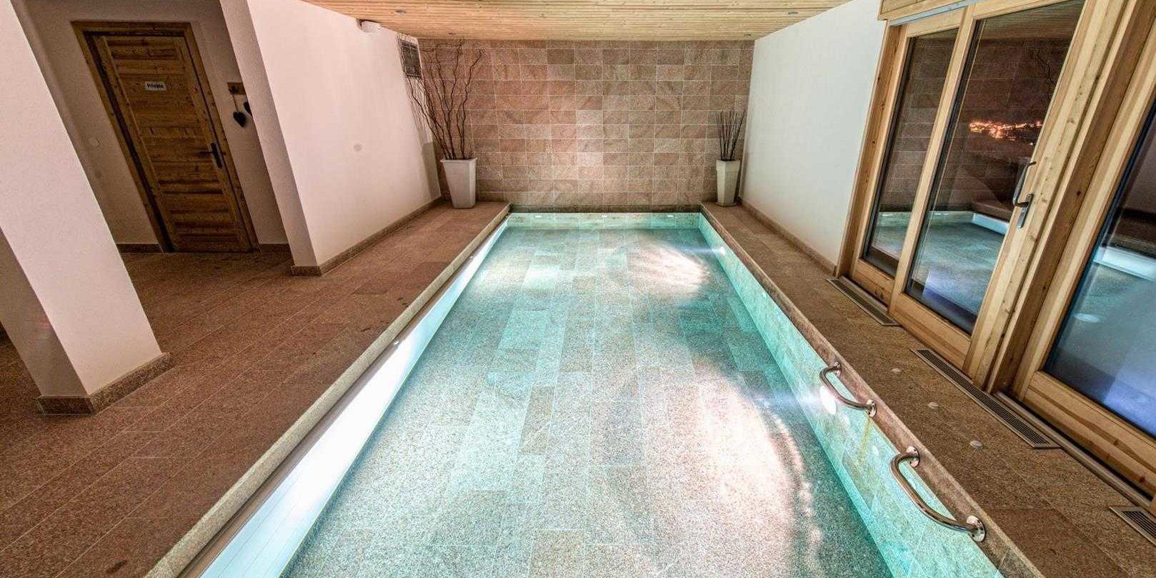 Chaletneuf du Tenne Chatel Les Portes du Soleil Frankrijk wintersport skivakantie luxe zwembad hoge ramen vazen houten plafond zwemmen ontspannen relaxen genieten