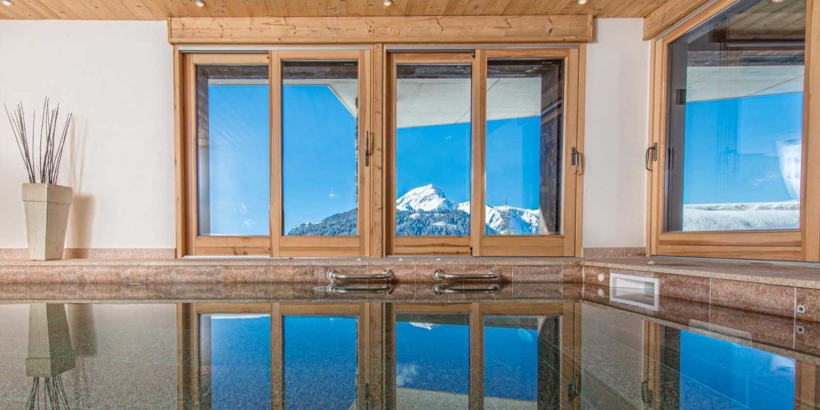 Chaletneuf du Tenne Chatel Les Portes du Soleil Frankrijk wintersport skivakantie luxe zwembad hoge ramen uitzicht besneeuwde bergen houten balken zwemmen ontspannen relaxen genieten