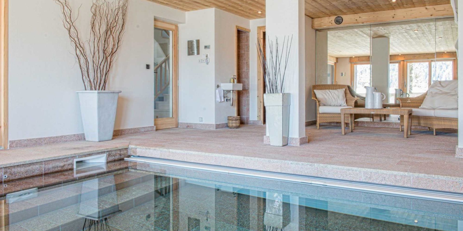 Chaletneuf du Tenne Chatel Les Portes du Soleil Frankrijk wintersport skivakantie luxe zwembad hoge ramen zitje fauteuils salontafel vazen houten balken zwemmen ontspannen relaxen genieten