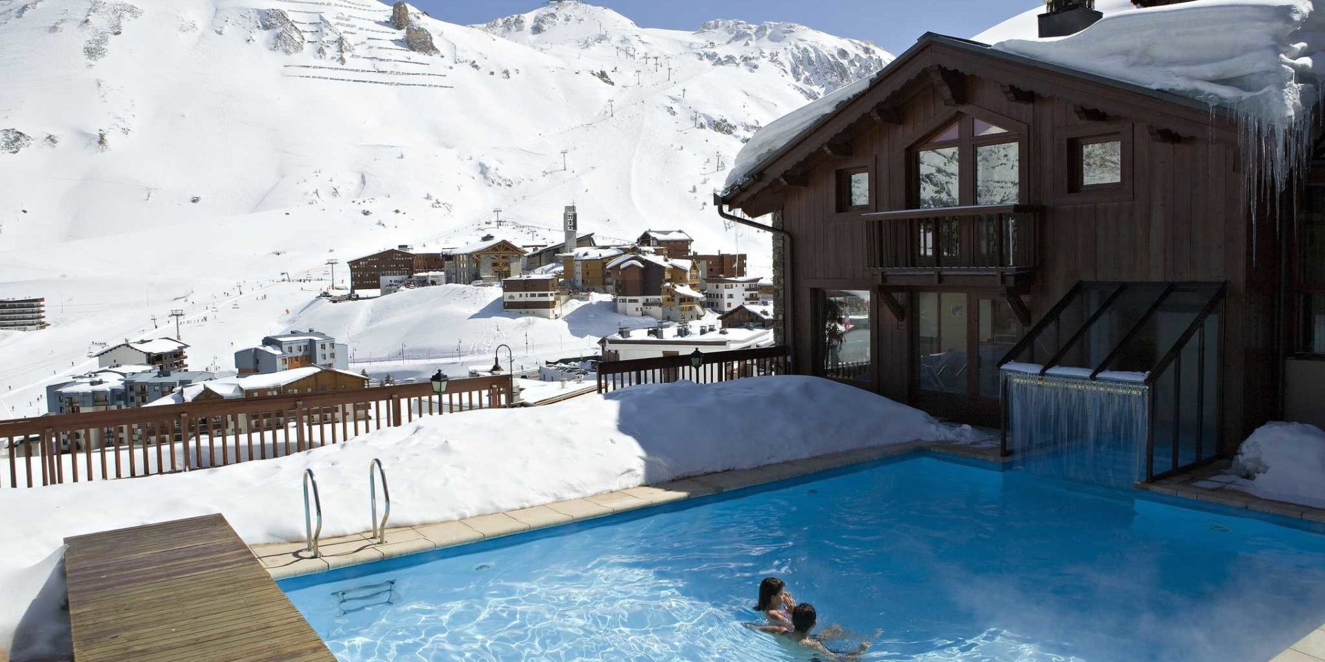 Hotel Village Montana Tignes Tignes-Val d'Isere Frankrijk wintersport skivakantie luxe buiten zwembad mensen Hotel Village Montana dorp Tignes besneeuwde bergen sneeuw zwemmen ontspannen relaxen genieten