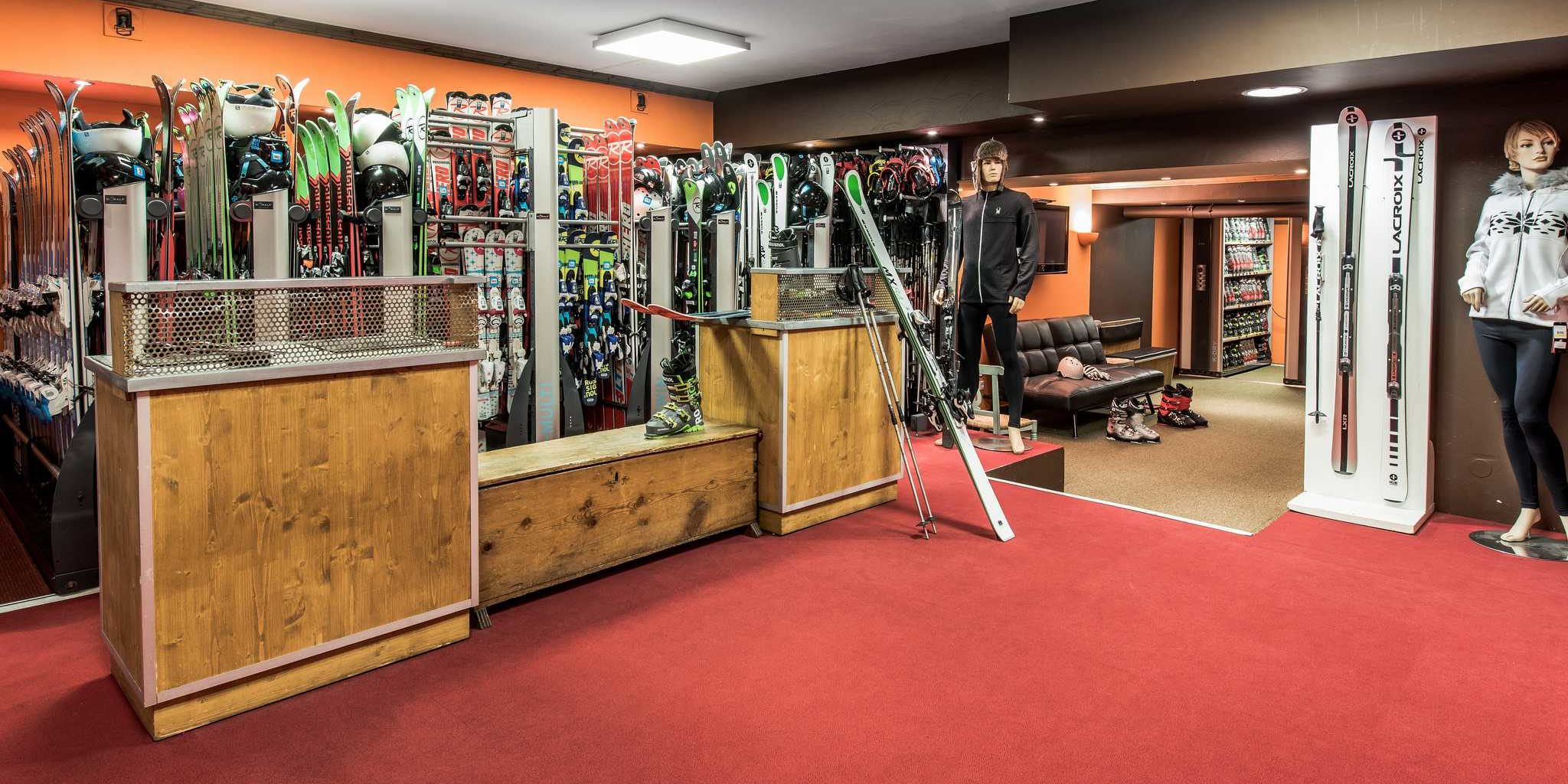 Hotel Village Montana Tignes Tignes-Val d'Isere Frankrijk wintersport skivakantie luxe skishop ski's helmen skischoenen ski accessoires zwart leren bank oranje muur rode vloerbedekking