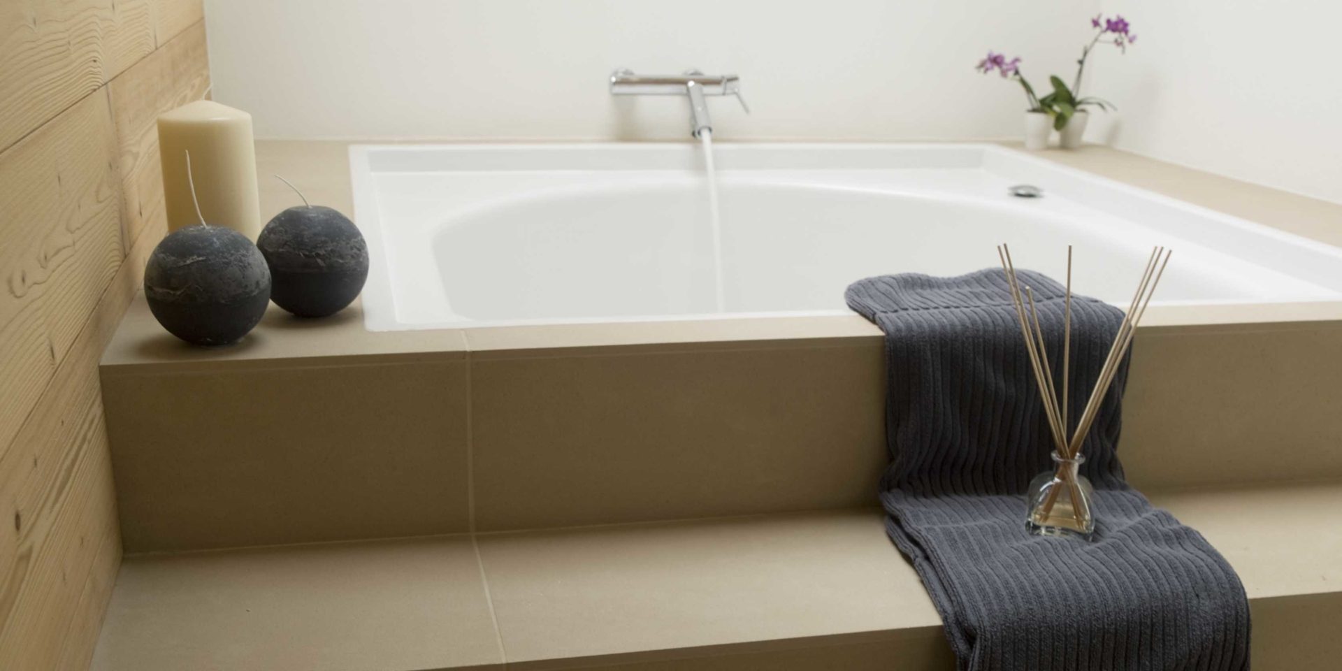 Maison Blanche et Verte Chatel Les Portes du Soleil Frankrijk wintersport skivakantie luxe badkamer bad grijze handdoek Orchidee kaarsen houten wand