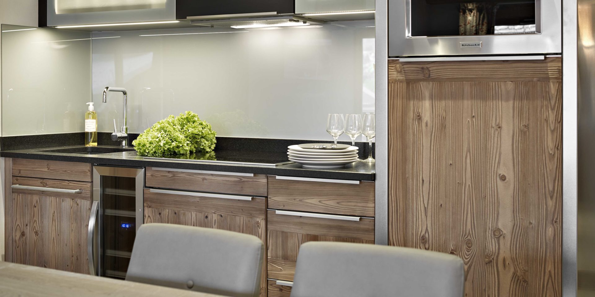 MGM Residence Alexane Samoens Le Grand Massif Frankrijk wintersport skivakantie luxe keuken gootsteen kookplaat servies grijze spatwand eettafel grijze stoelen